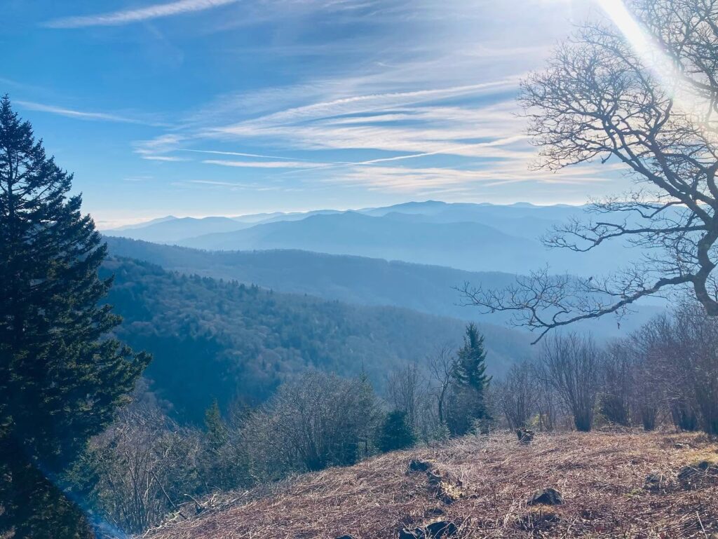 Layered blue mountain ridges under a bright sky, photographed by Adam Neuerburg on a hike