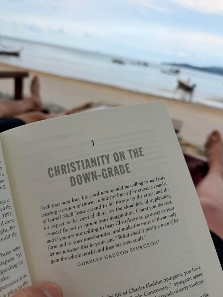 Adam Neuerburg reading Christianity on the Down-Grade by Charles Haddon Spurgeon on the beach