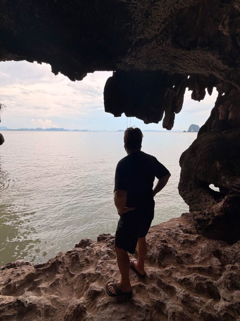 Adam Neuerburg standing in a sea cave looking out over Phang Nga Bay, Thailand