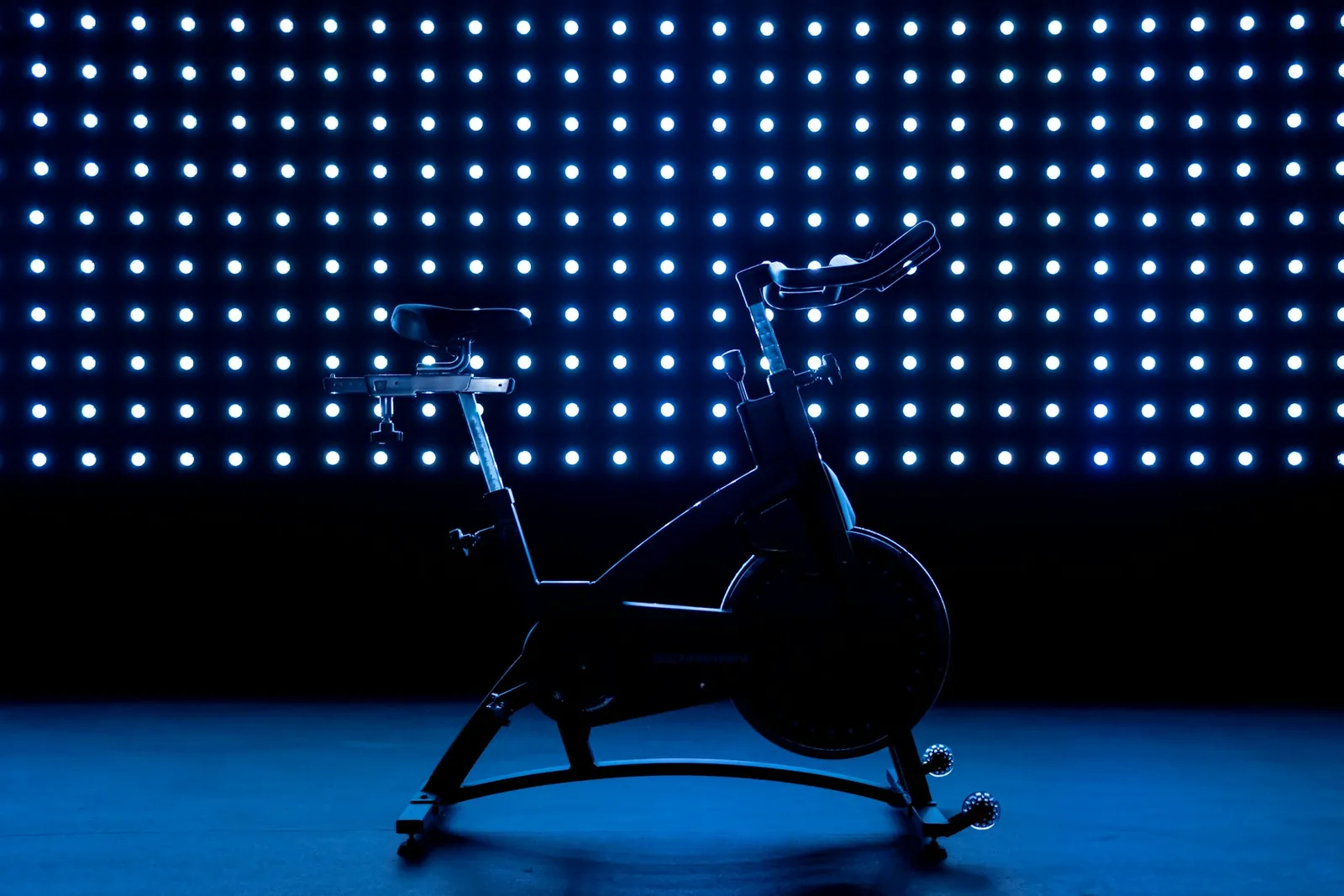 Stationary spin bike under blue lights in a dark studio