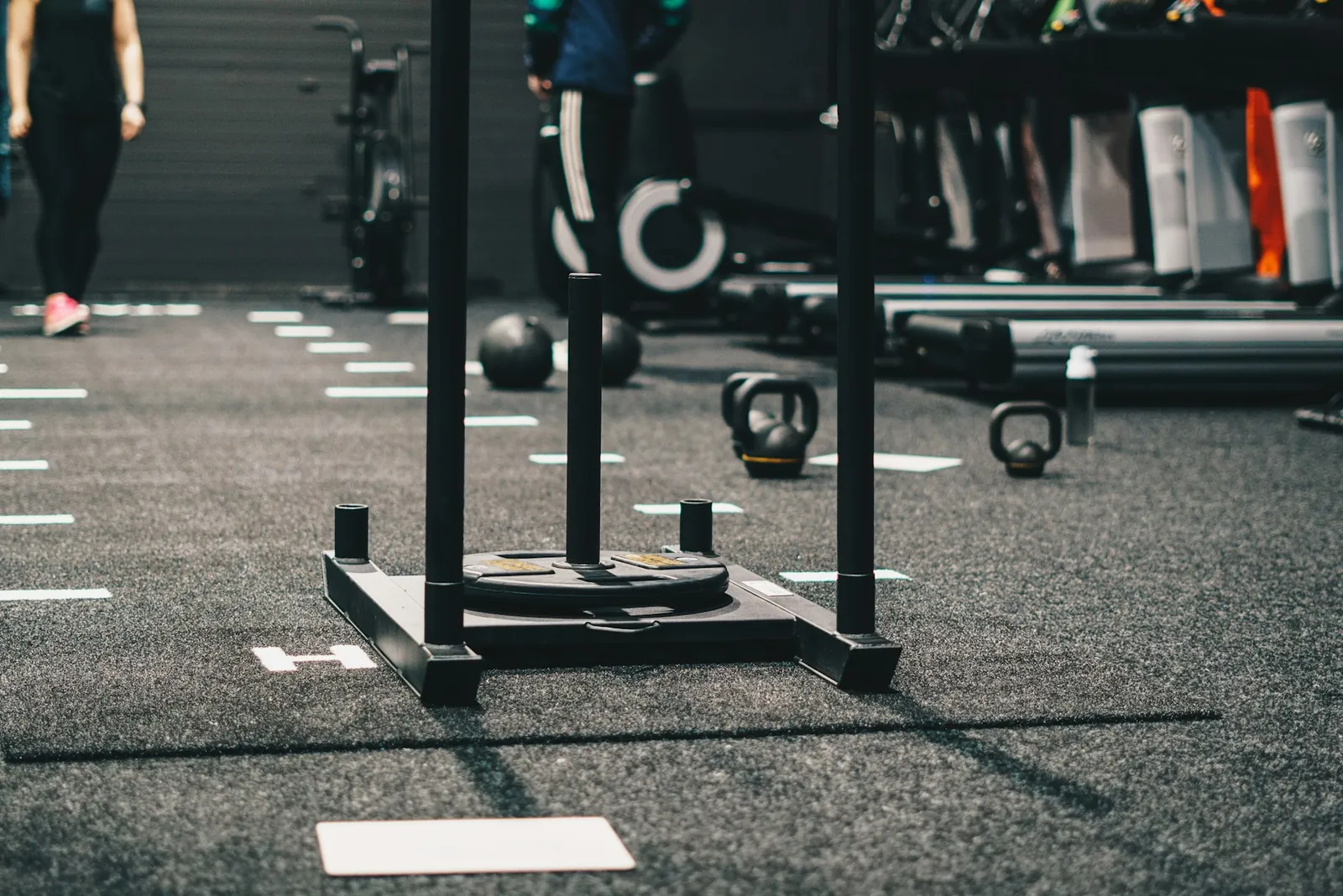 Weight sled on a marked turf lane with kettlebells and medicine balls