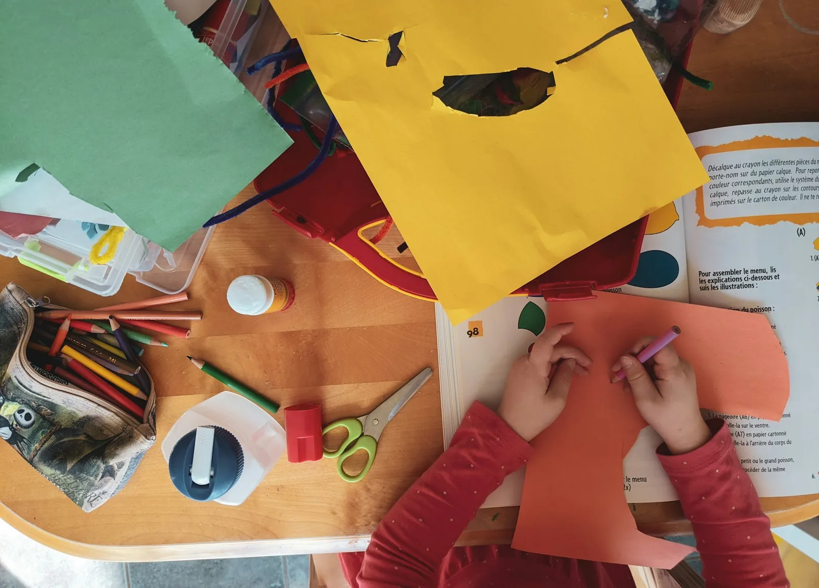 Kids cutting and gluing colorful paper crafts