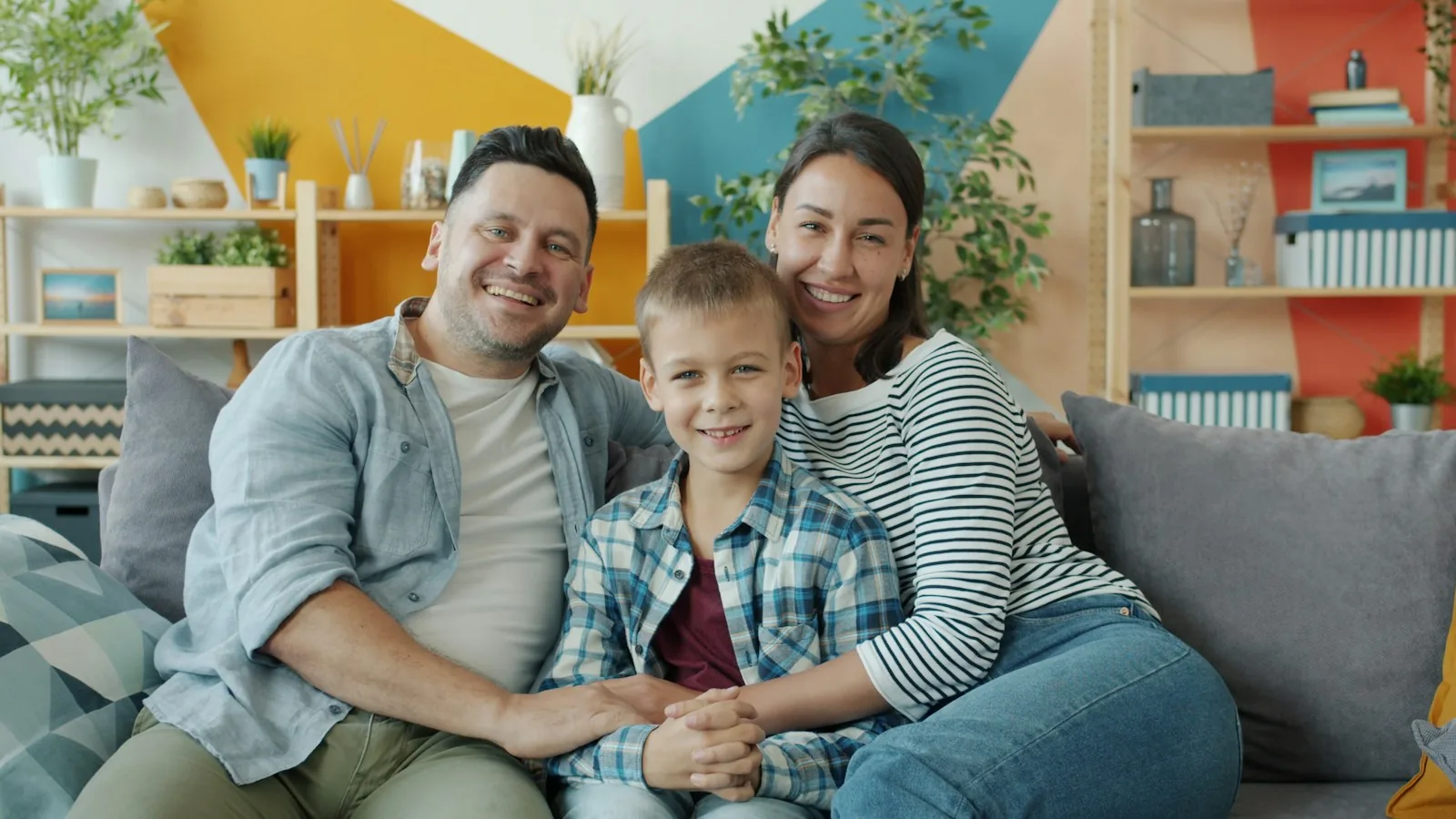 Smiling family of three relaxing together on a couch