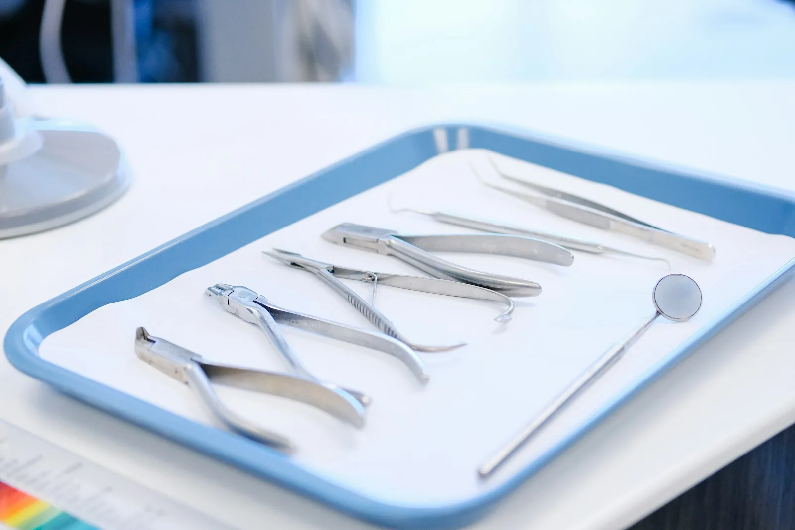 Dental instruments laid out on a light-blue tray