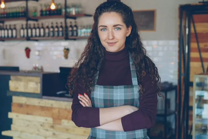 Smiling café owner standing in her coffee shop