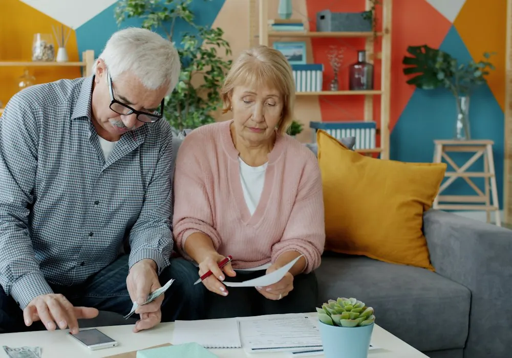 Retired couple on their couch going over documents together