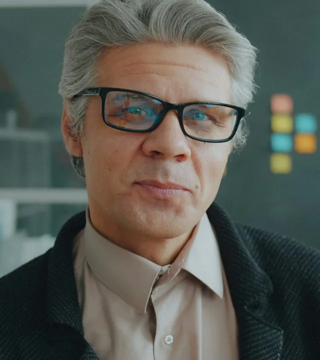 Portrait of Russ Calloway, a gray-haired advisor in glasses