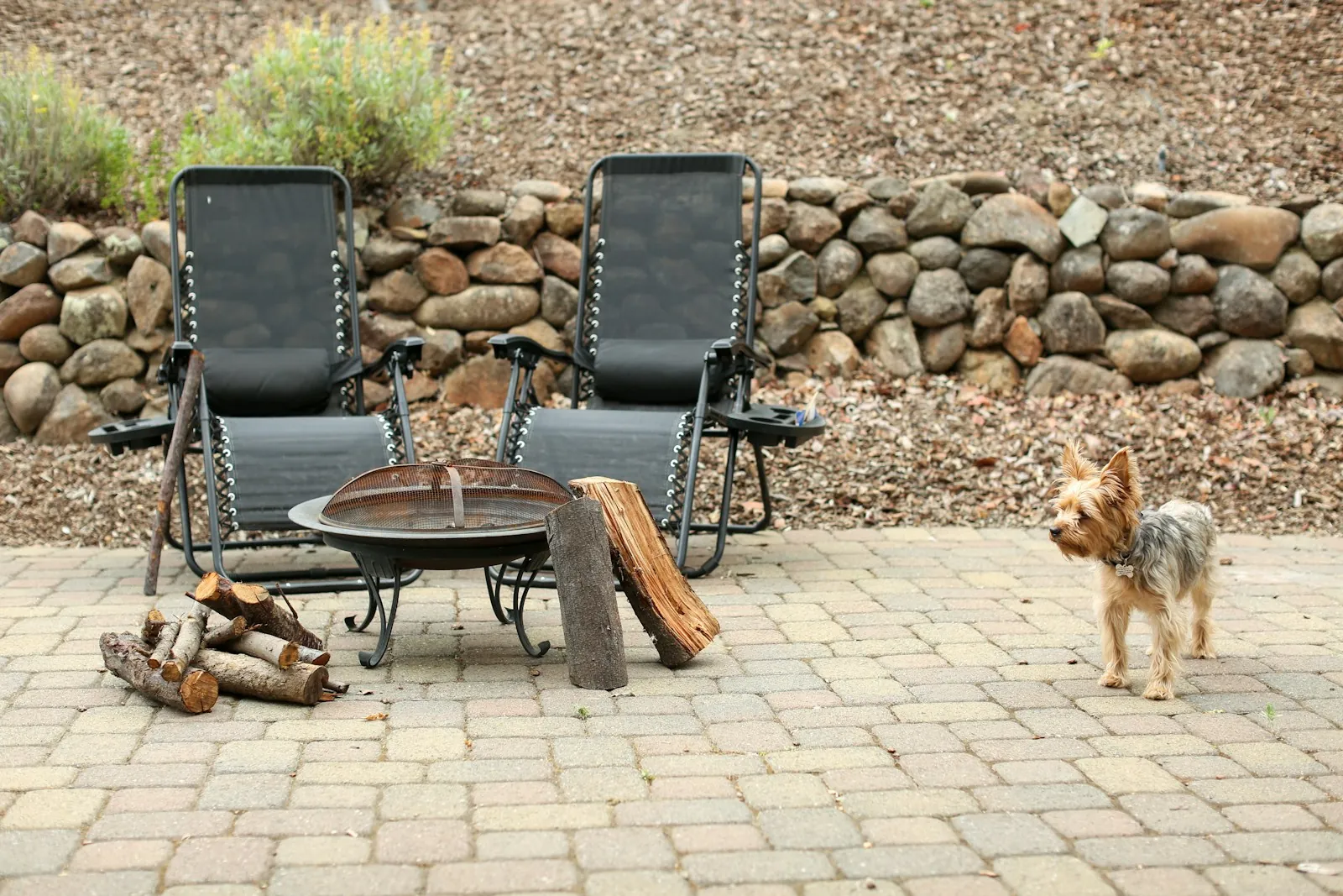 Paver patio with lounge chairs around a fire pit