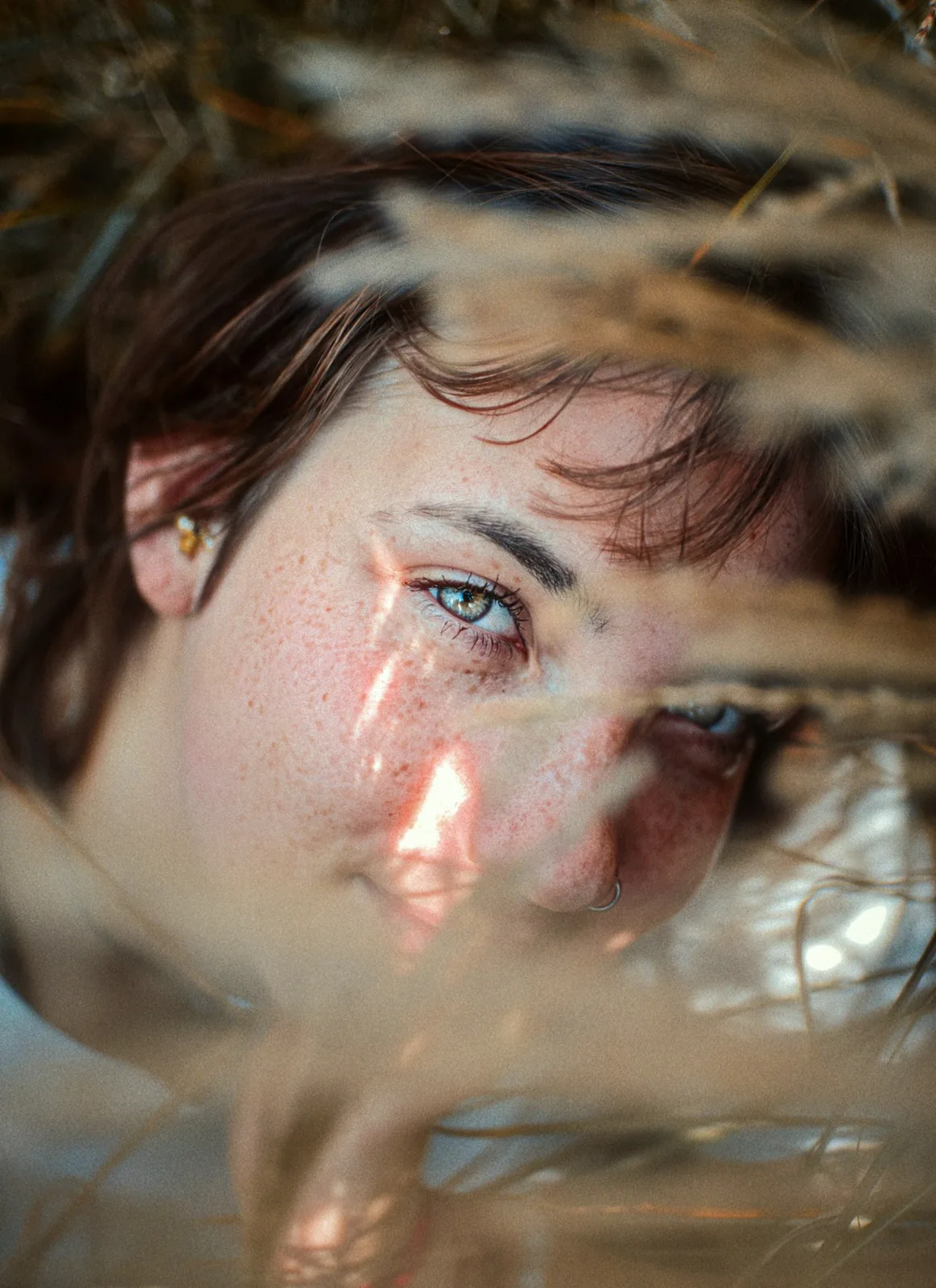 Woman's face refracted through a glass prism with streaks of light