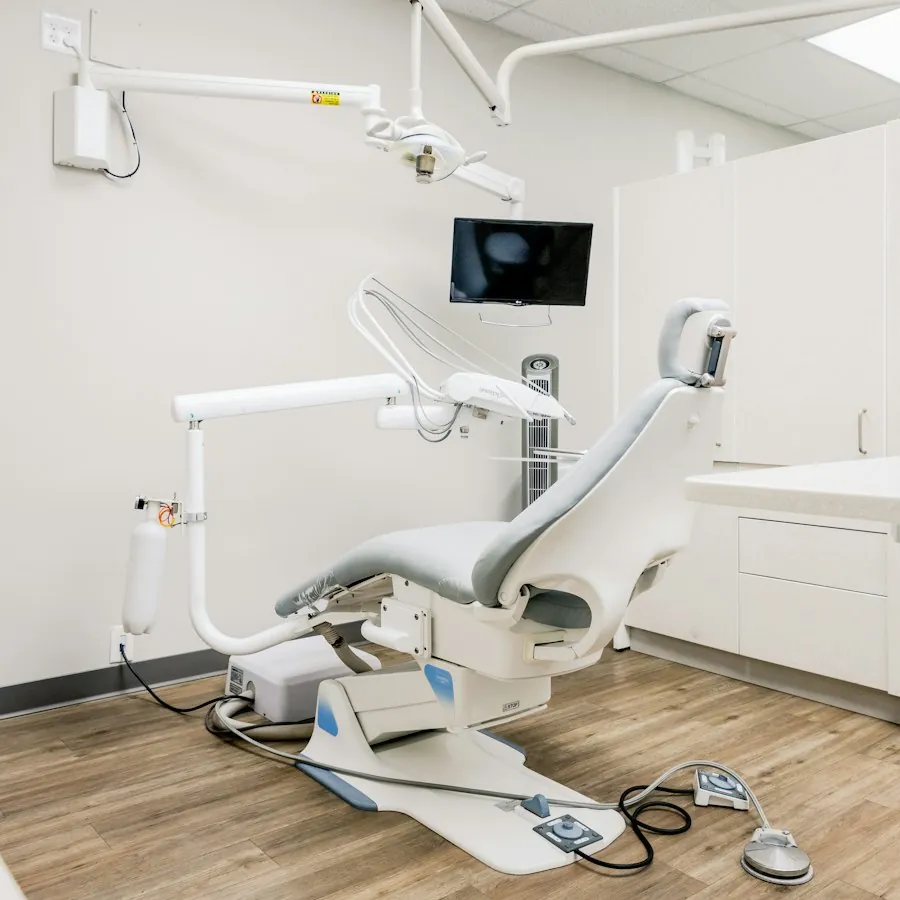 Bright dental operatory with a patient chair and a wall-mounted monitor