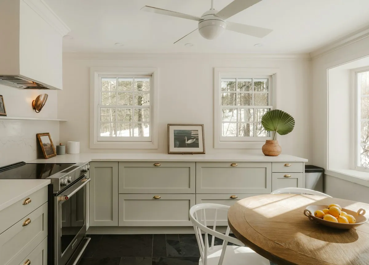Bright, freshly cleaned kitchen with a bowl of oranges on a wooden table