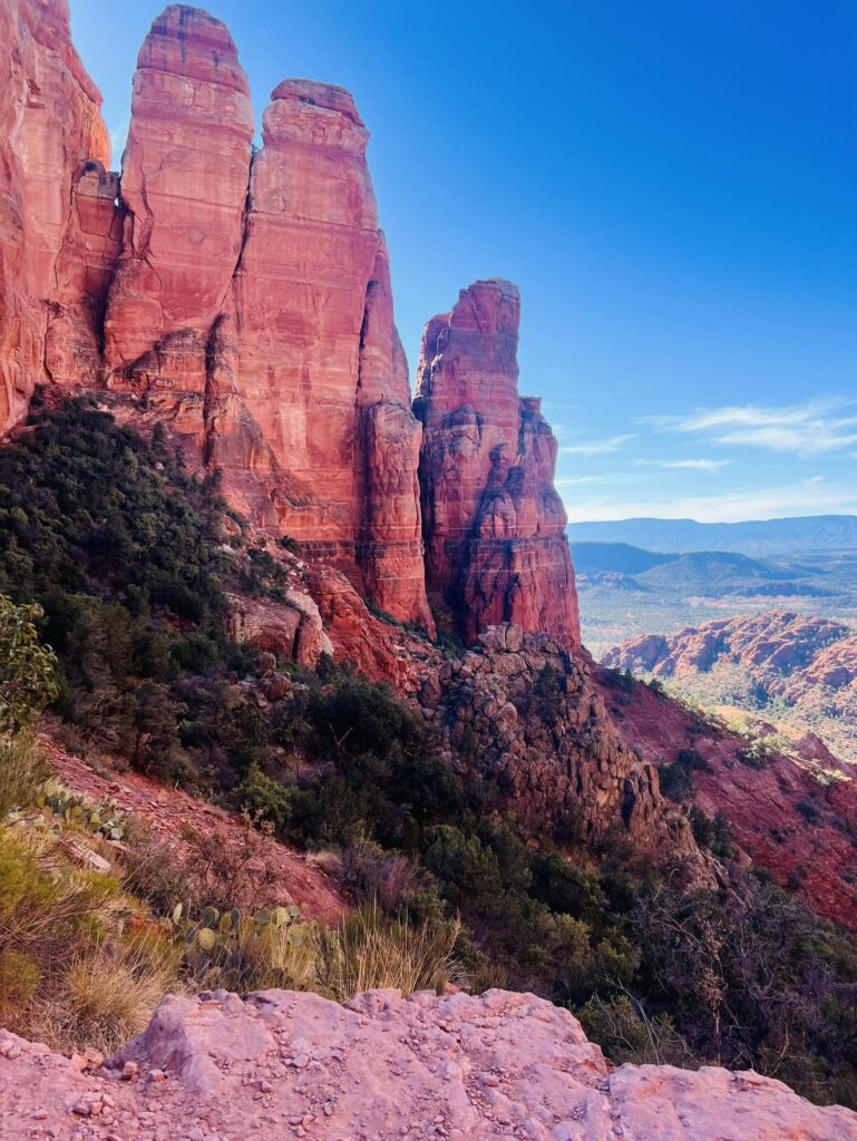 Towering red rock spires against a blue sky, photographed by Adam Neuerburg while hiking