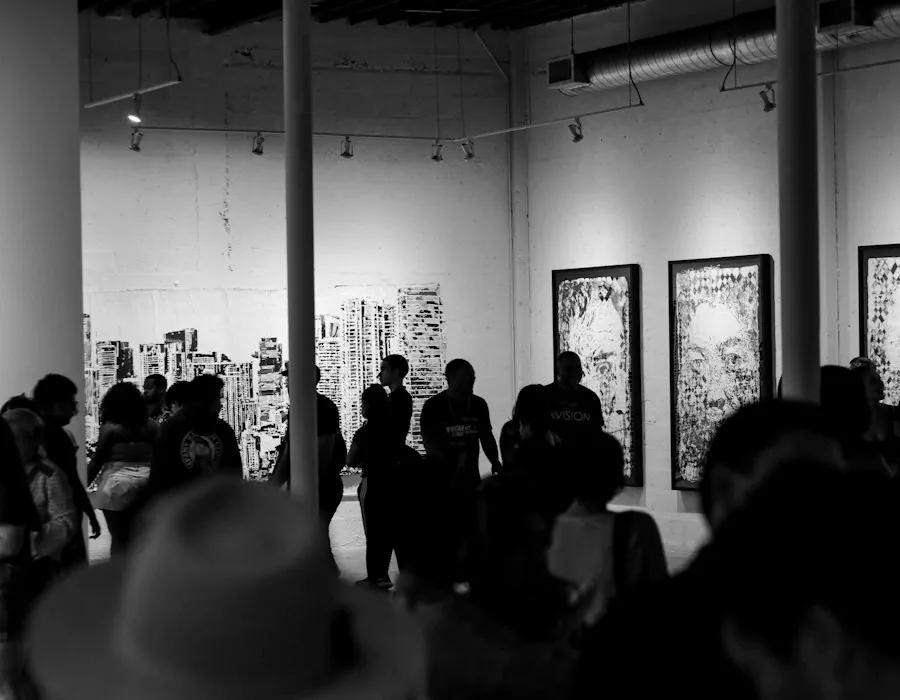 Opening-night crowd in silhouette in front of large framed drawings