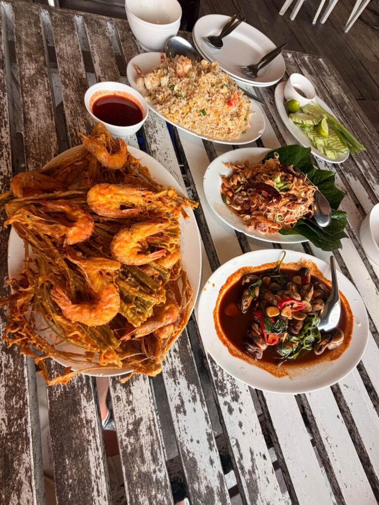 A table of Thai seafood dishes with fried shrimp, curry and rice from Adam Neuerburg's travels