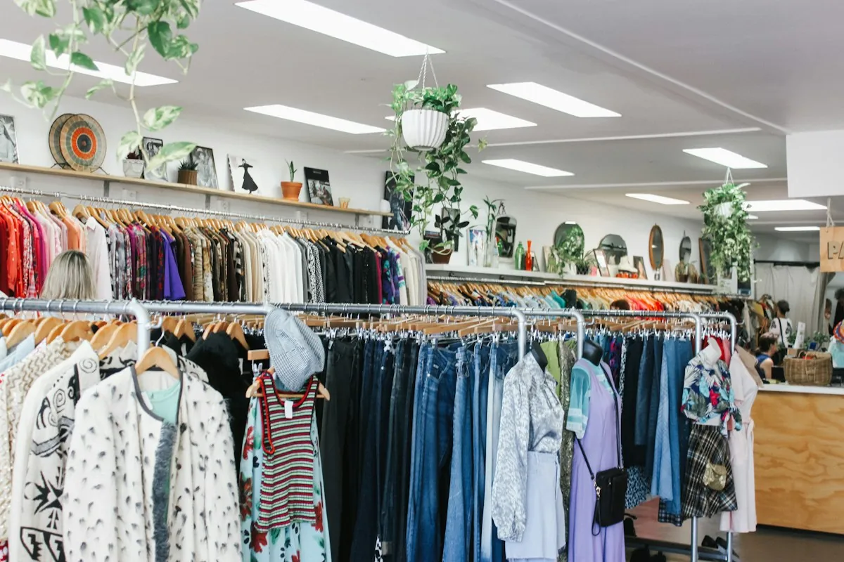 Bright boutique floor with racks of colorful vintage clothing
