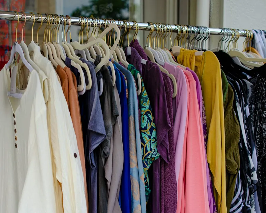 Rack of colorful secondhand shirts and dresses with a handwritten sign